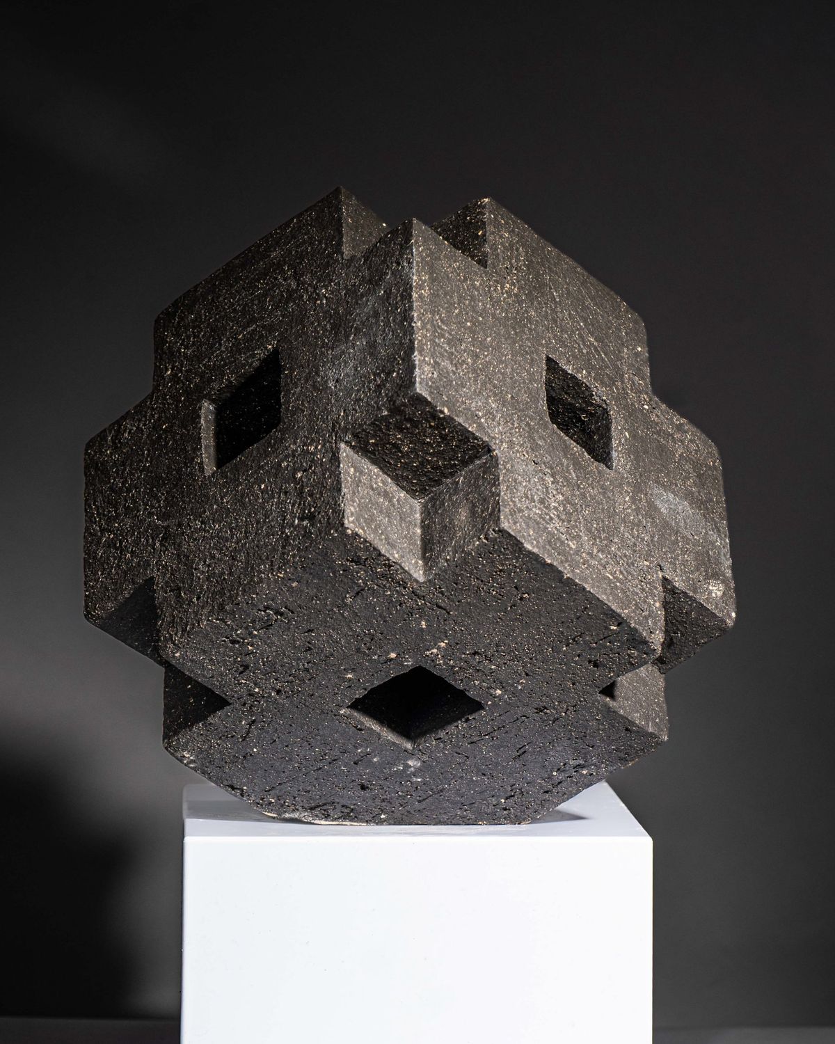 Dark textured geometric sculpture with square openings