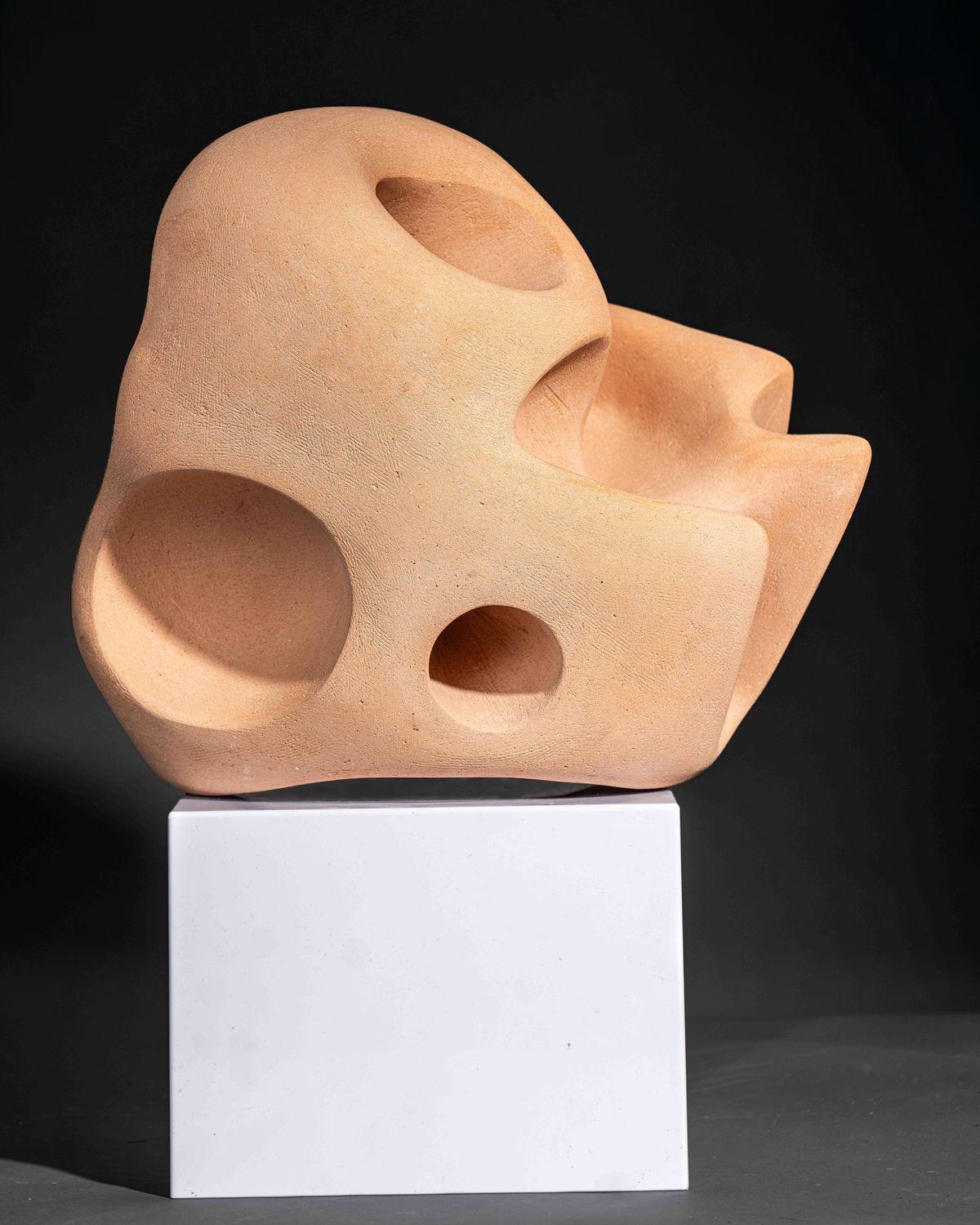 Pale terracotta sculpture with rounded hollows and openings