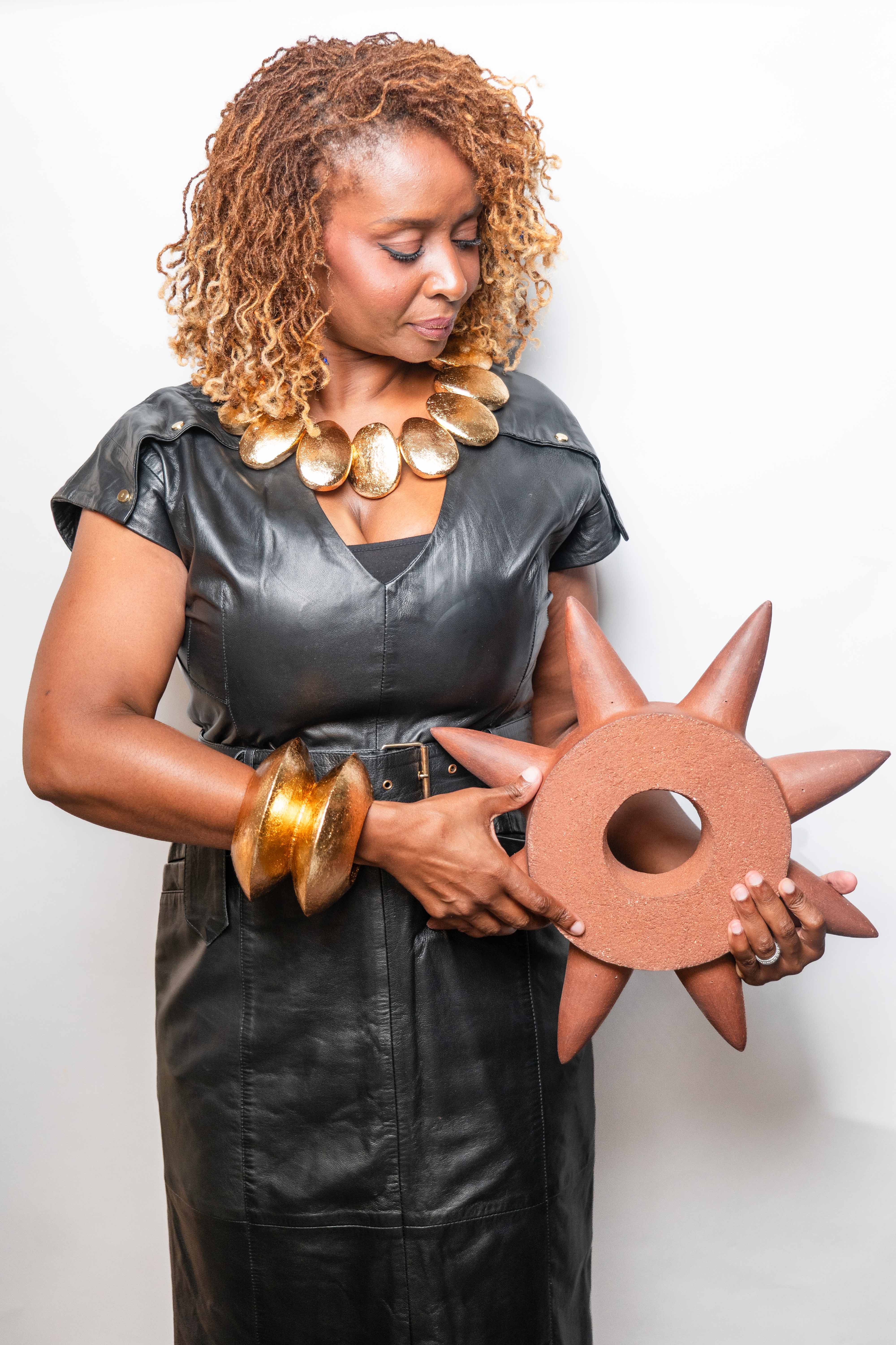 Nana Berchie holding a sculptural work